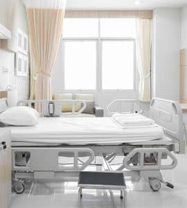 Ziekenhuisbed met absorberende bedonderlegger ter bescherming van het matras – geschikt voor incontinentiezorg in zorginstellingen of thuiszorg.